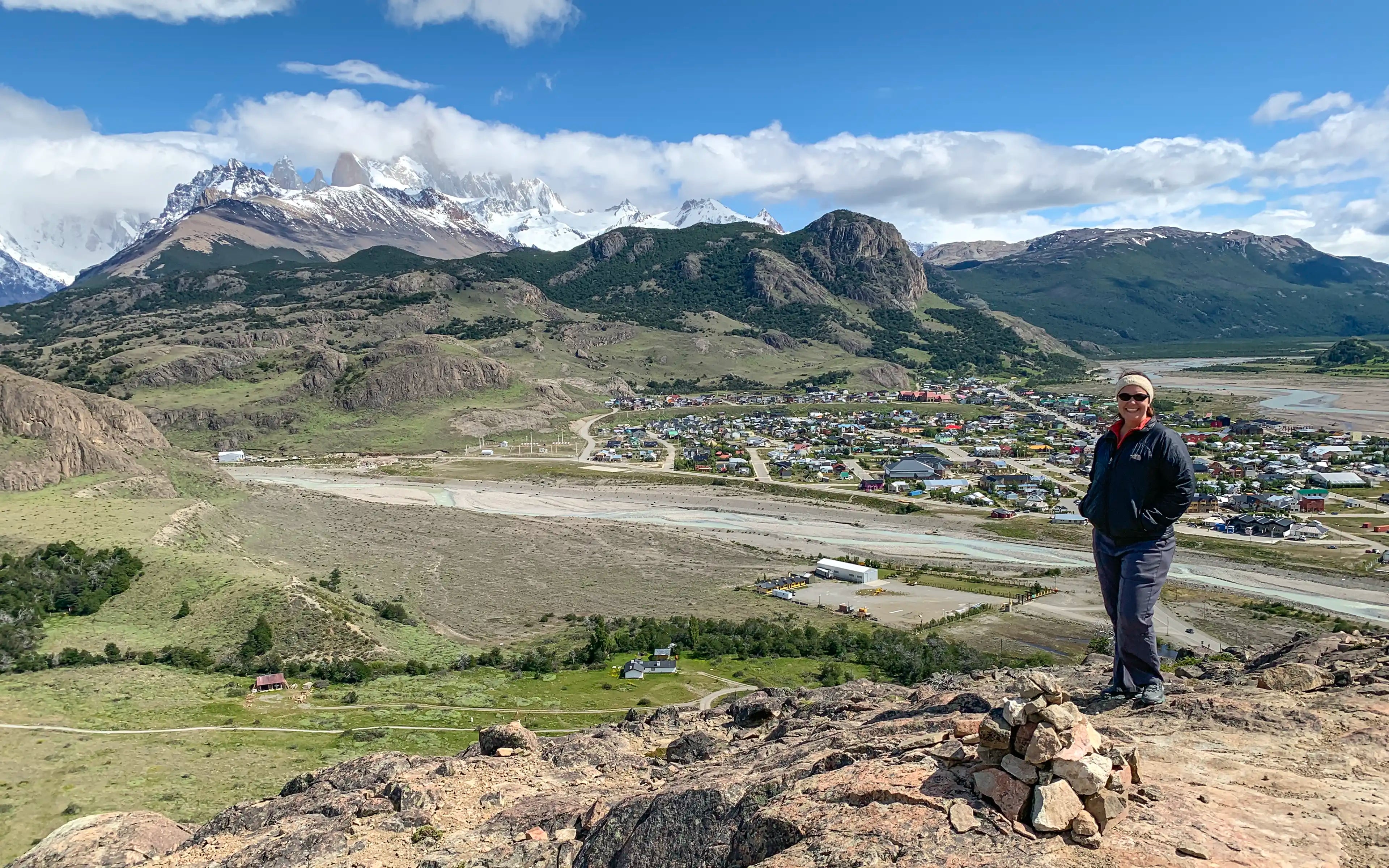 A woman standing at Mirador de los Cóndores in El Chaltén, Argentina overlooking the town and Fitz Roy.