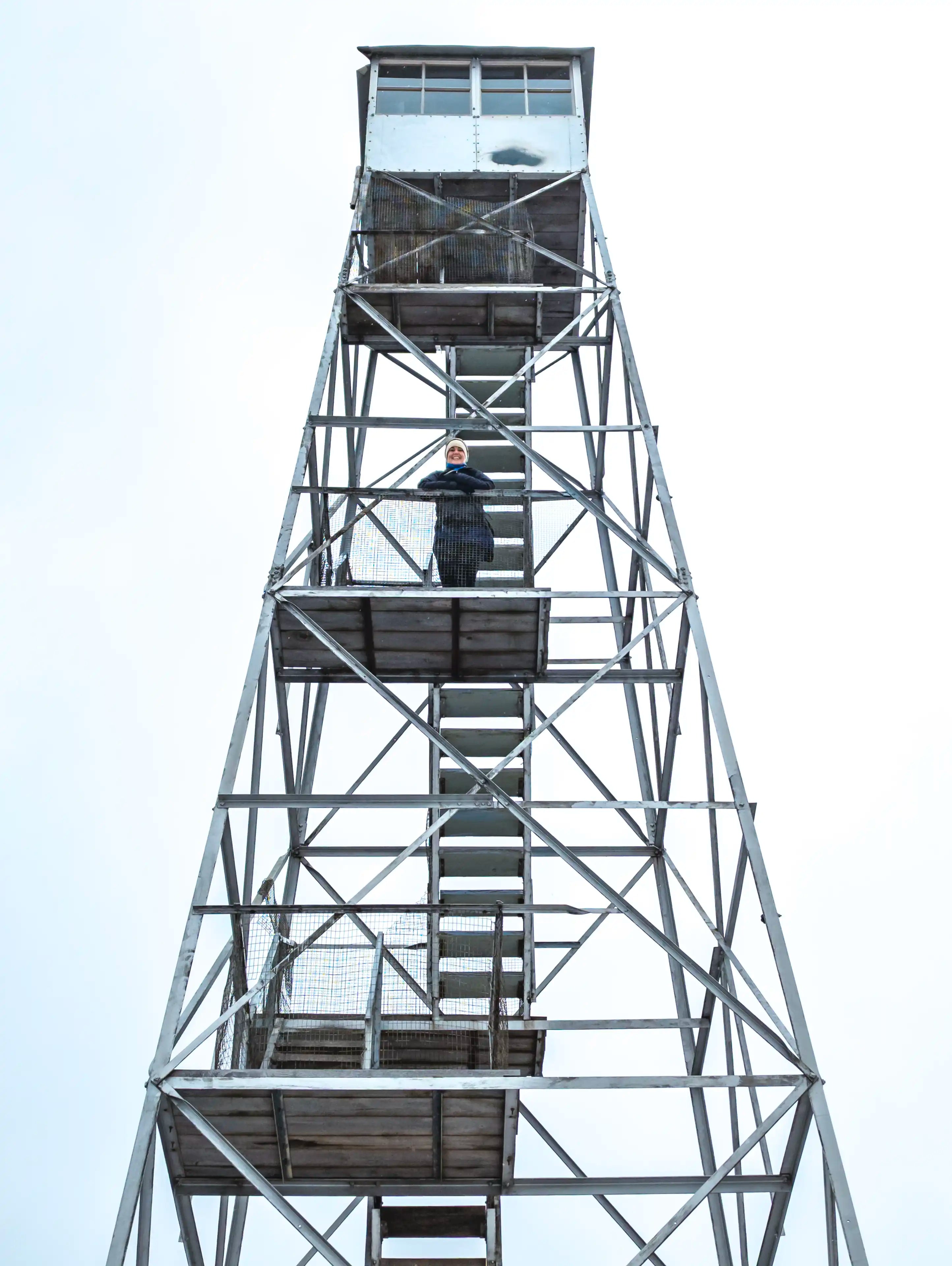 A woman standing on the Overlook Mountain fire tower in New York.