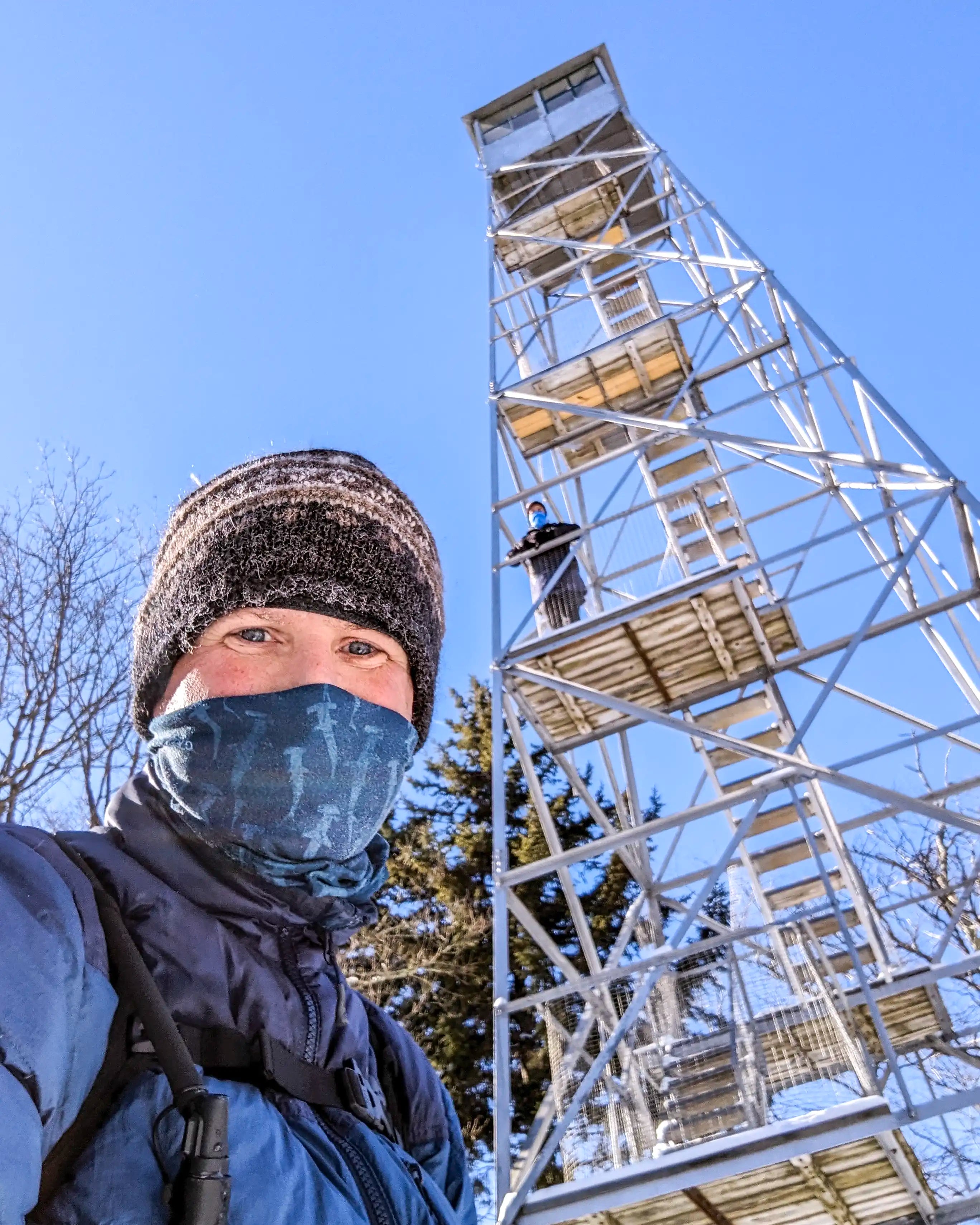 A male and female hiker at the Red Hill Fire Tower in New York wearing the Ancash Packable Daypack by Deep Ascent.