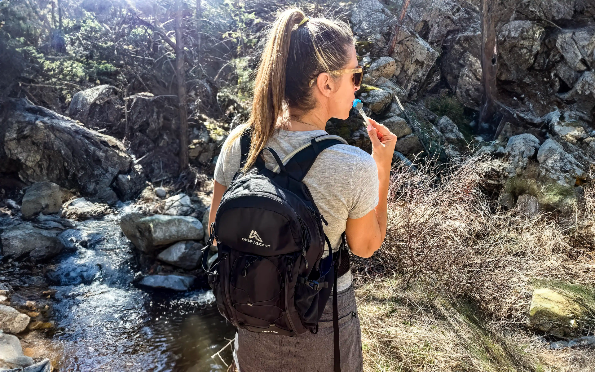 A woman hiking with the Ancash Packable Daypack by Deep Ascent.